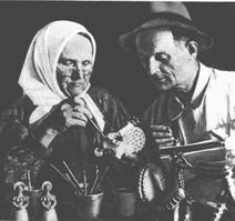 16. Мастерицам, не видевшим при жизни Елизавету Александровну Кошкину есть возможность разглядеть отличные фотографии она за работой, расписывает, тут же огромный ком глины, медник с ковшом, деревянная лопатка. Рядом уважаемый Алексей Иванович Деньшин, он